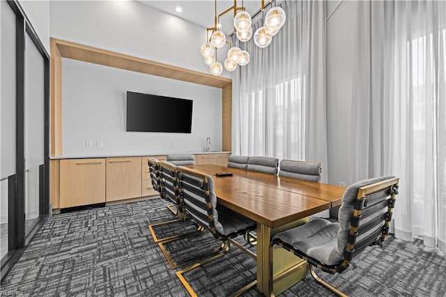 dining space with an inviting chandelier and dark carpet