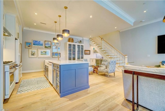 kitchen with light countertops, high quality appliances, open floor plan, and light wood finished floors