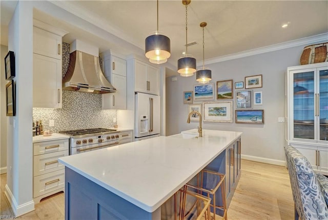 kitchen with light countertops, ornamental molding, decorative backsplash, wall chimney exhaust hood, and high end appliances