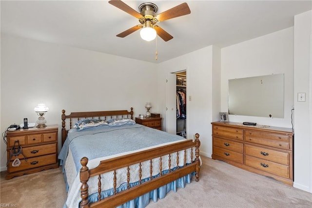 bedroom with baseboards, light colored carpet, ceiling fan, a spacious closet, and a closet