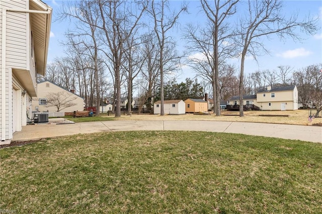 view of yard with an outbuilding, central AC unit, and a residential view