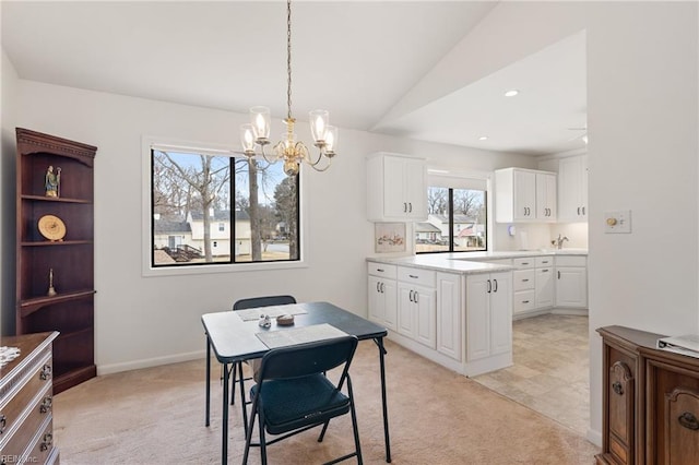 dining room featuring light carpet, baseboards, lofted ceiling, a notable chandelier, and recessed lighting