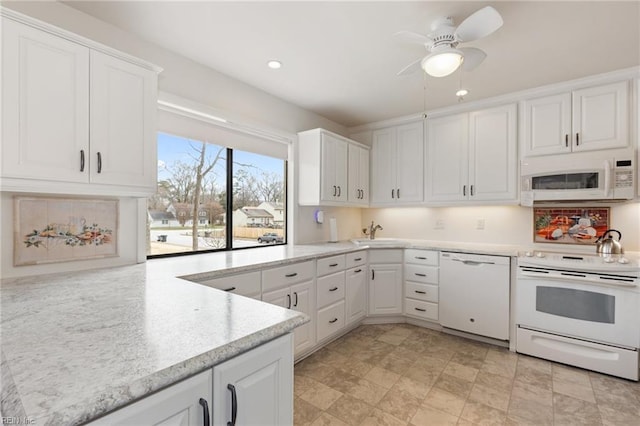 kitchen with white appliances, white cabinetry, and a sink