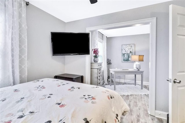 bedroom featuring wood finished floors, a ceiling fan, and baseboards