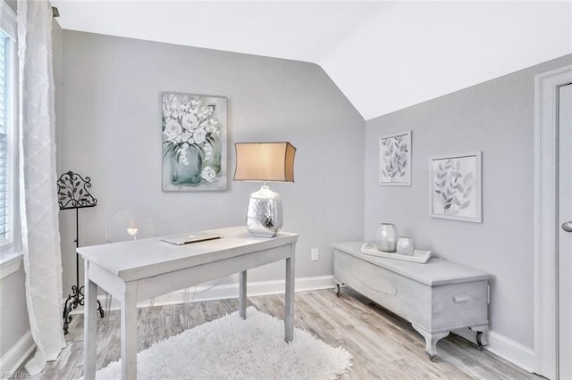 office space with lofted ceiling, light wood-type flooring, and baseboards