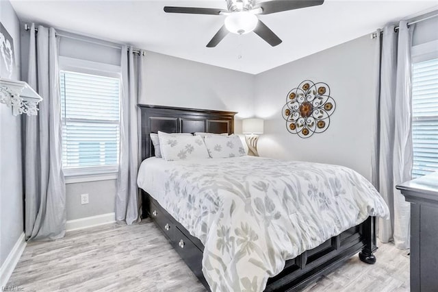 bedroom with baseboards, ceiling fan, and light wood-style floors