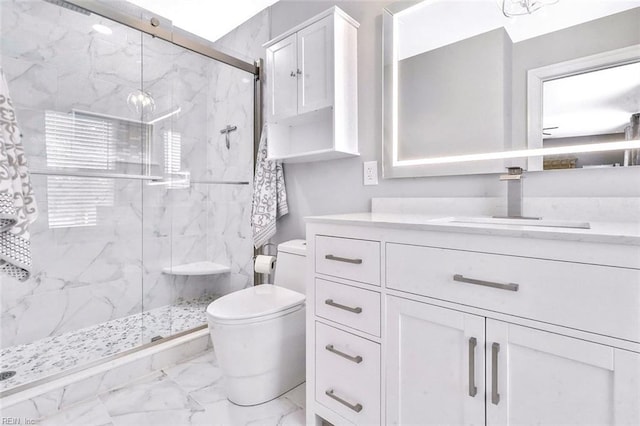 bathroom with marble finish floor, toilet, vanity, and a marble finish shower