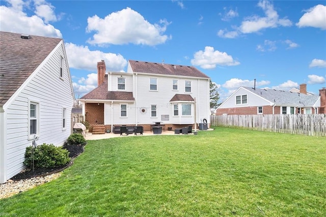 back of house with a patio area, a lawn, a chimney, and fence