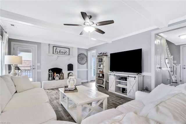 living area featuring a fireplace, ornamental molding, and wood finished floors