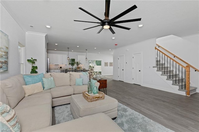 living room with ornamental molding, recessed lighting, stairway, and wood finished floors