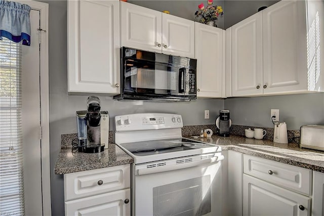 kitchen featuring white cabinetry, black microwave, and white range with electric cooktop