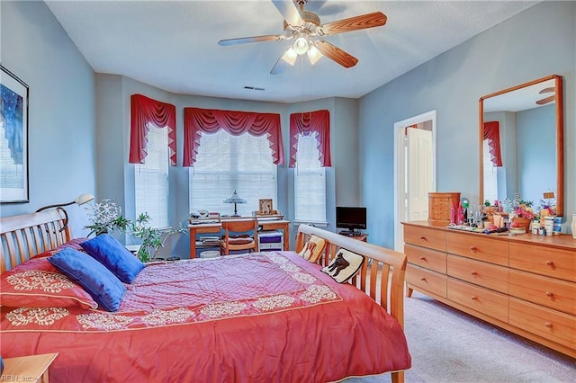 carpeted bedroom with ceiling fan and visible vents