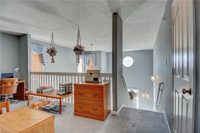 living area featuring carpet, a textured ceiling, and an upstairs landing