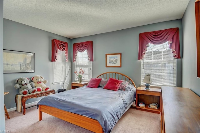 bedroom featuring a textured ceiling, baseboards, and carpet flooring