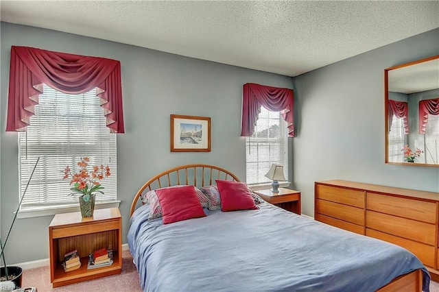 bedroom with carpet floors, a textured ceiling, and baseboards