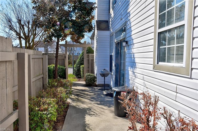 view of side of home featuring fence and a patio