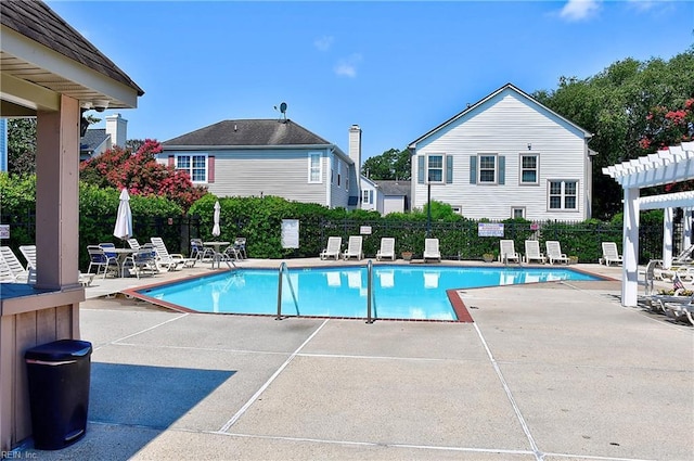 pool with a patio area, fence, and a pergola