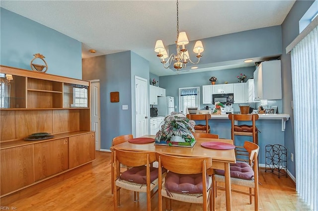 dining area with light wood finished floors, baseboards, and a chandelier