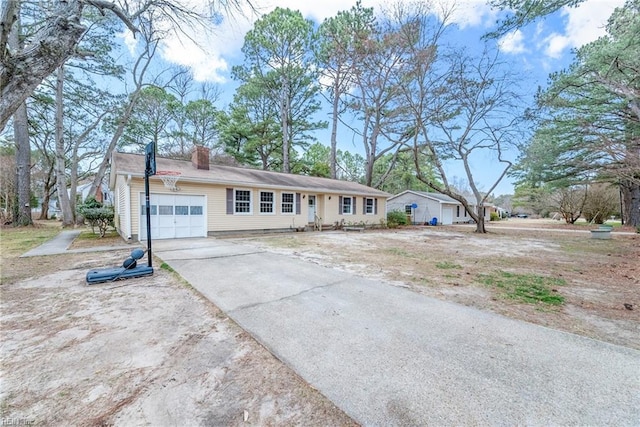 single story home featuring a garage, driveway, and a chimney