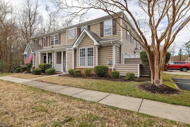 view of front of house with a front yard and brick siding