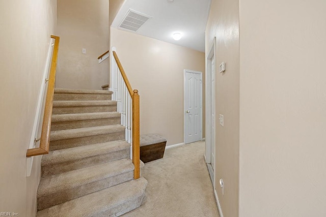 staircase featuring carpet floors, visible vents, and baseboards