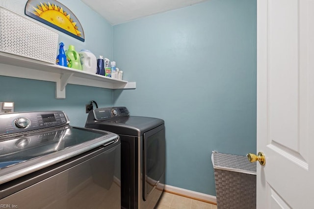 laundry area with washer and dryer, laundry area, light tile patterned flooring, and baseboards