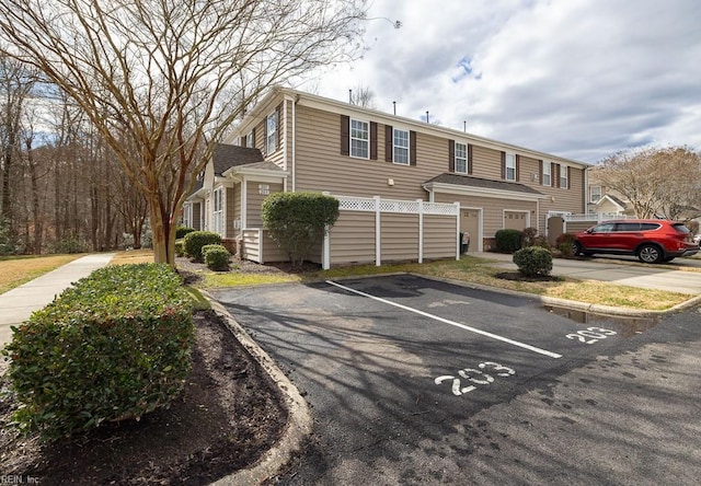 view of property with uncovered parking and fence