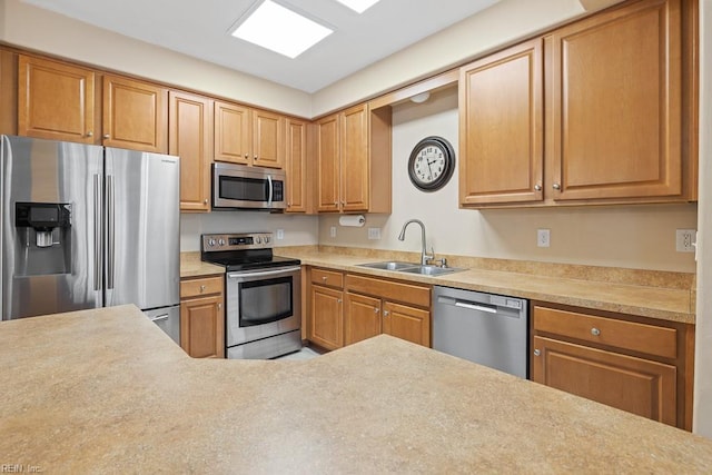 kitchen featuring stainless steel appliances, a sink, and light countertops