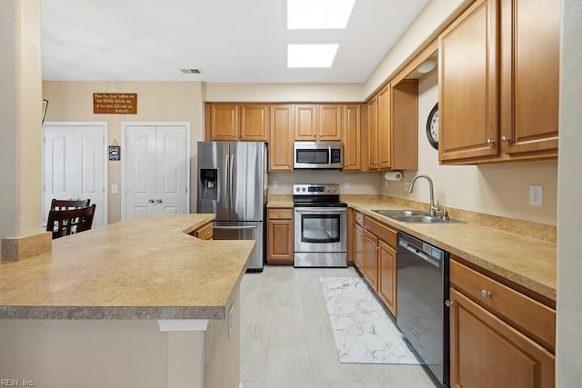 kitchen featuring visible vents, appliances with stainless steel finishes, light countertops, and a sink