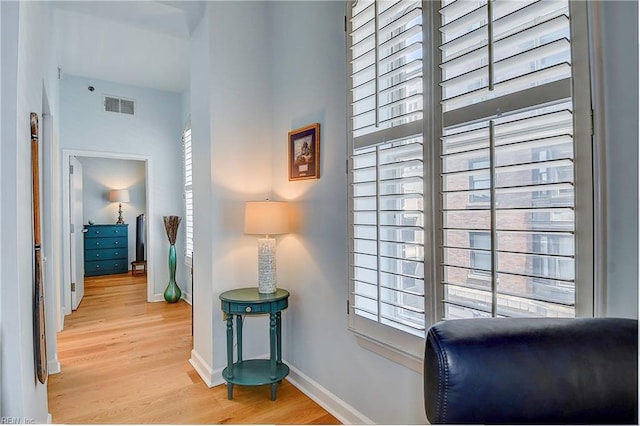 sitting room featuring light wood-style floors, baseboards, and visible vents