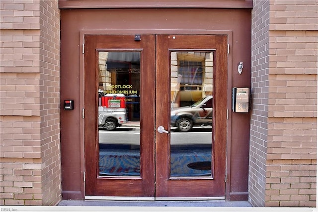 property entrance featuring french doors and brick siding