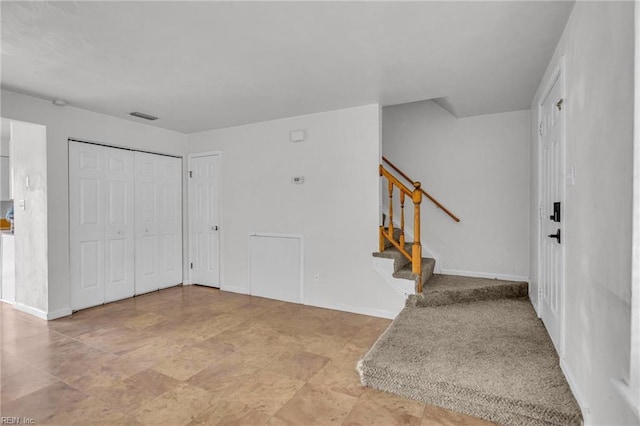 foyer with stairs, visible vents, and baseboards