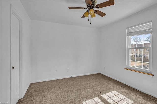 carpeted empty room with ceiling fan and baseboards