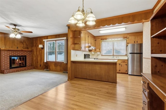 kitchen with wooden walls, open floor plan, range with electric stovetop, freestanding refrigerator, and open shelves