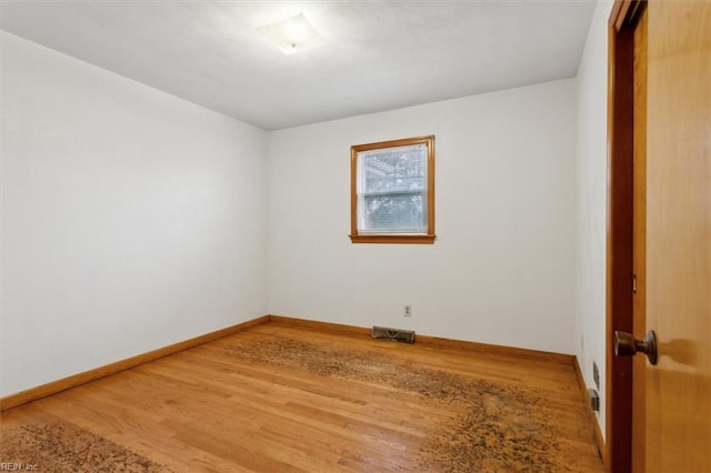 unfurnished room with visible vents, baseboards, and wood finished floors