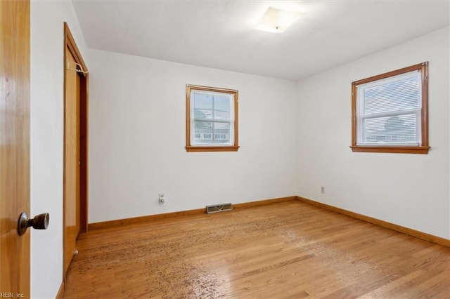 spare room with visible vents, light wood-style flooring, and baseboards