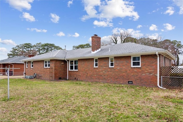 back of house featuring brick siding, crawl space, a yard, and fence