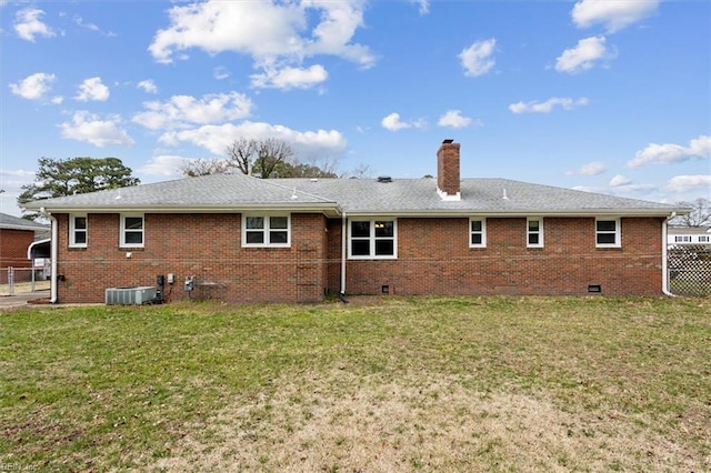 rear view of house featuring crawl space, a lawn, a chimney, and fence