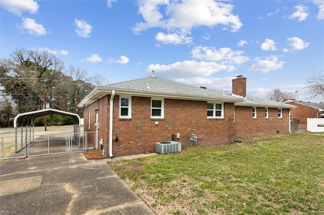 view of property exterior with brick siding, a detached carport, fence, a lawn, and a gate