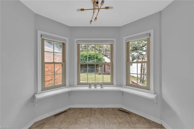 unfurnished sunroom featuring plenty of natural light, visible vents, and a notable chandelier