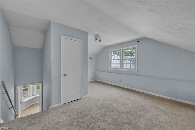 bonus room with a wealth of natural light, carpet flooring, vaulted ceiling, and baseboards