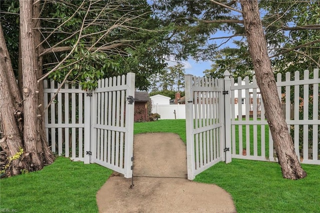 view of gate with fence and a yard