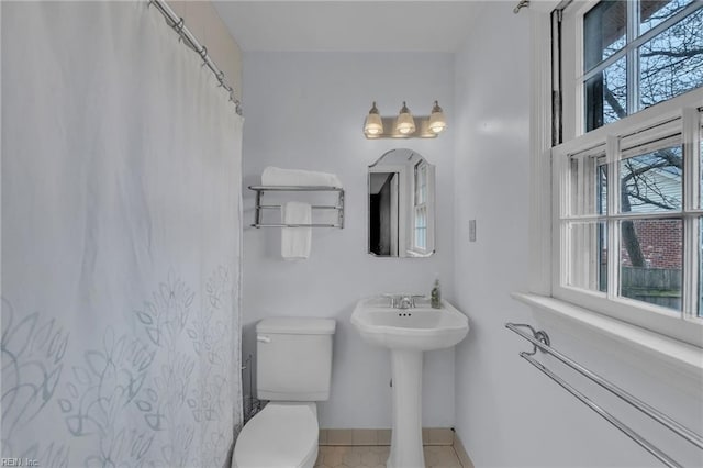 full bathroom with toilet, baseboards, and tile patterned floors