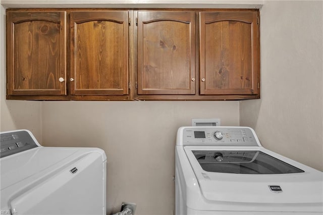 washroom with cabinet space and washing machine and dryer