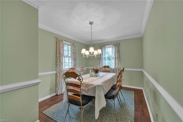 dining room with ornamental molding, a notable chandelier, baseboards, and wood finished floors