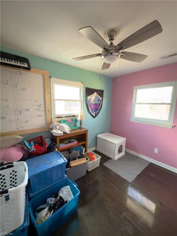 bedroom featuring multiple windows, visible vents, baseboards, and wood finished floors