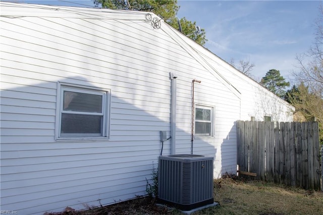 view of side of home featuring central AC and fence