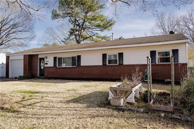 ranch-style home featuring a garage, a front yard, a vegetable garden, and brick siding