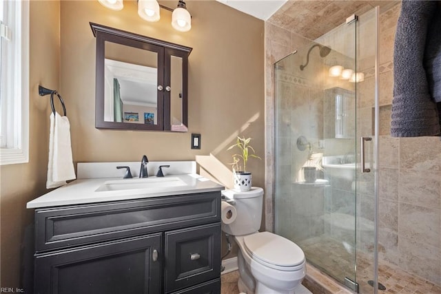 full bathroom featuring toilet, a shower stall, baseboards, and vanity