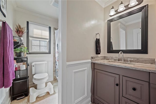 bathroom with wainscoting, crown molding, vanity, and toilet